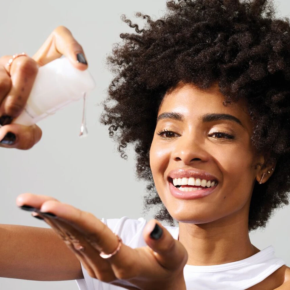 Modelo aplicando Olaplex Nº9 Sérum en el cabello para mejorar suavidad, manejabilidad y protección del peinado.