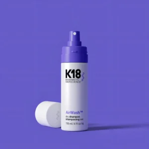 K18 AirWash shampoo en seco no aerosol sobre fondo púrpura, producto profesional que elimina olores y reduce sebo con OdorBIND™ – Bonjour Salón.