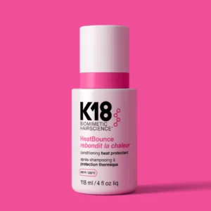 K18 HeatBounce protector térmico y acondicionador leave-in 118 ml sobre fondo rosa, protección hasta 232°C con tecnología resilicore™ — Bonjour Salón.
